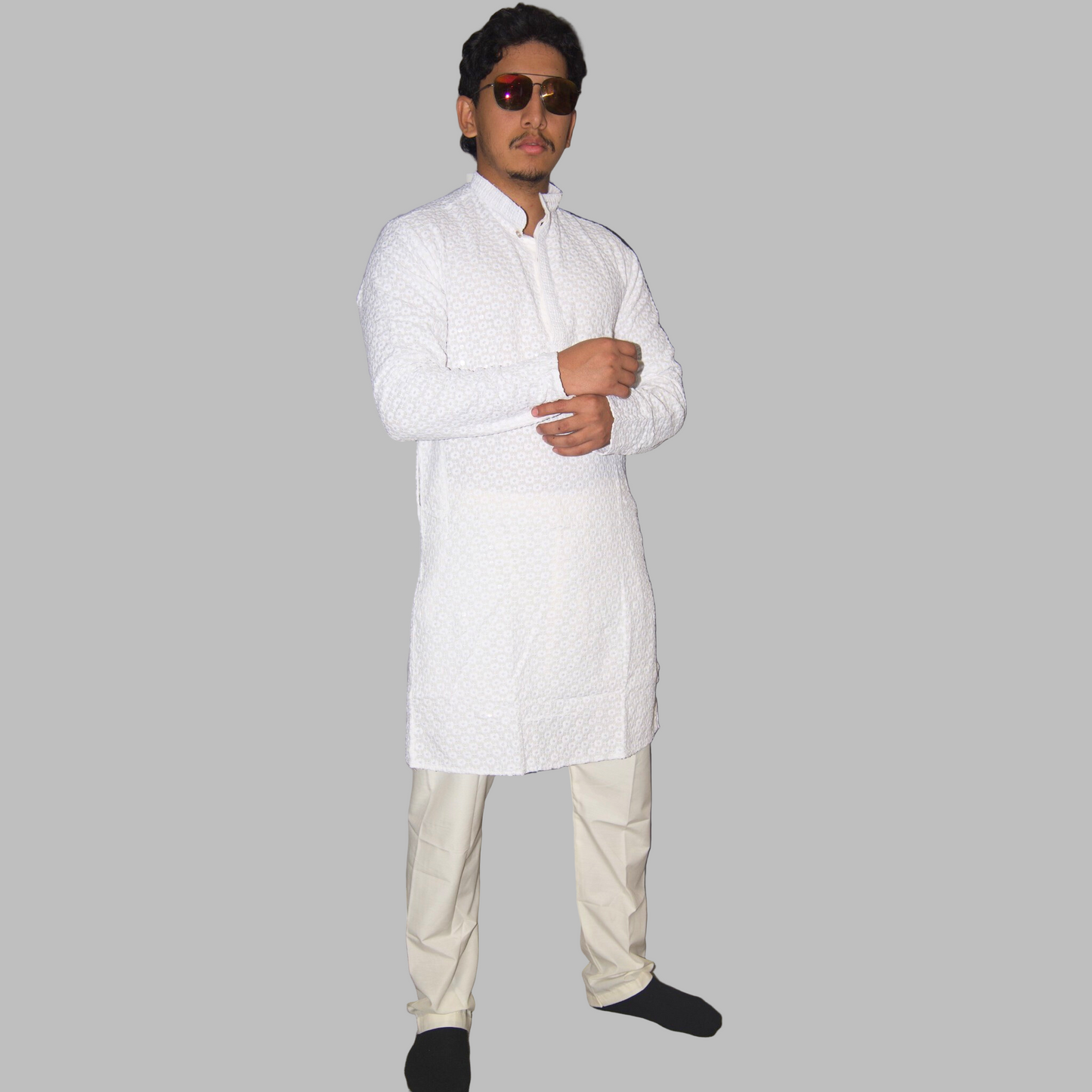 Man wearing a white kurta with beige pants against a plain background