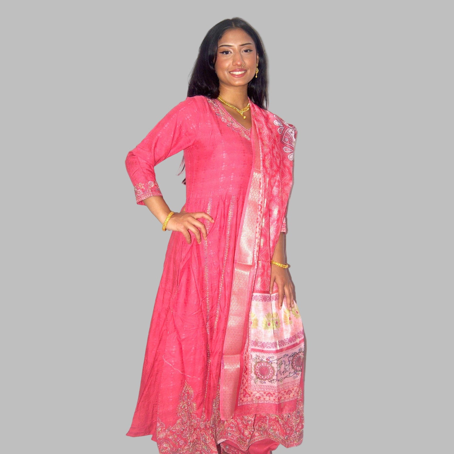 Woman wearing a pink traditional outfit with a matching dupatta on a white background