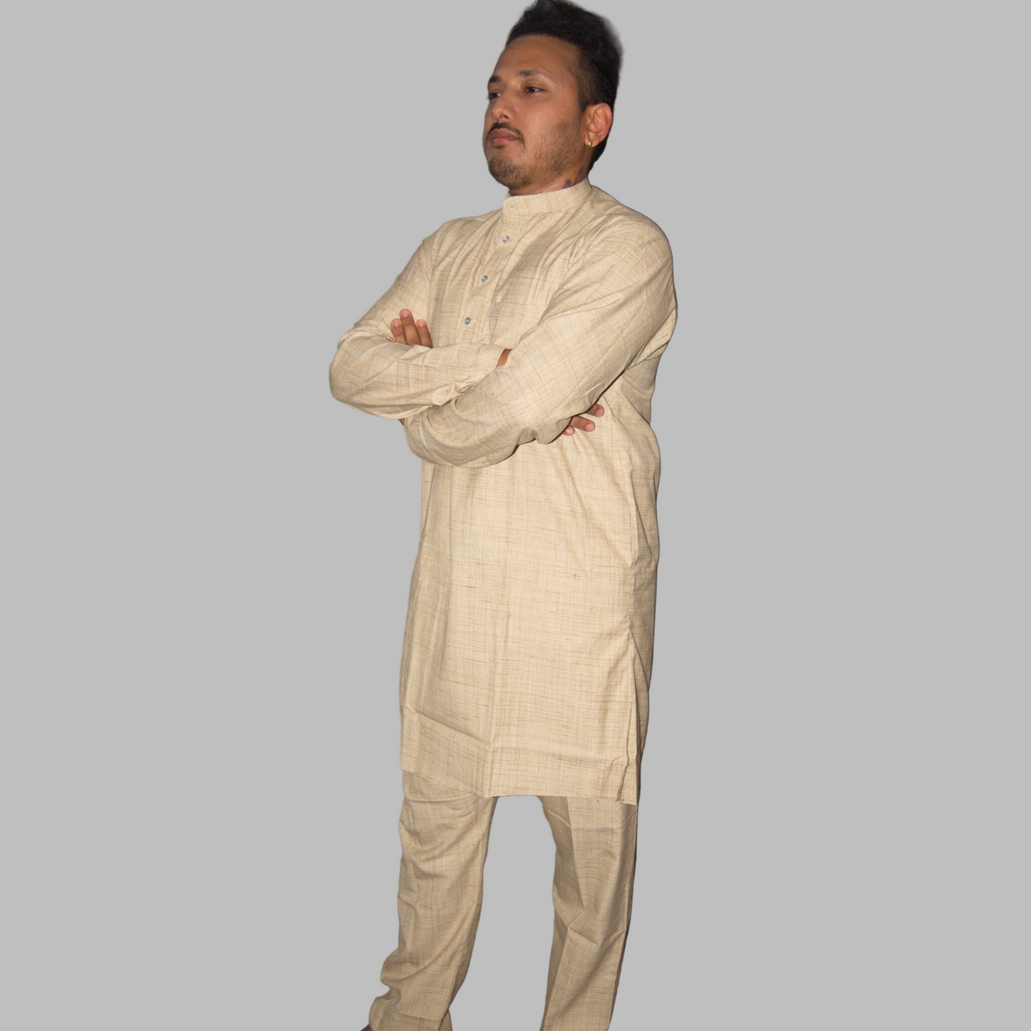 Man wearing a beige kurta with a plain background