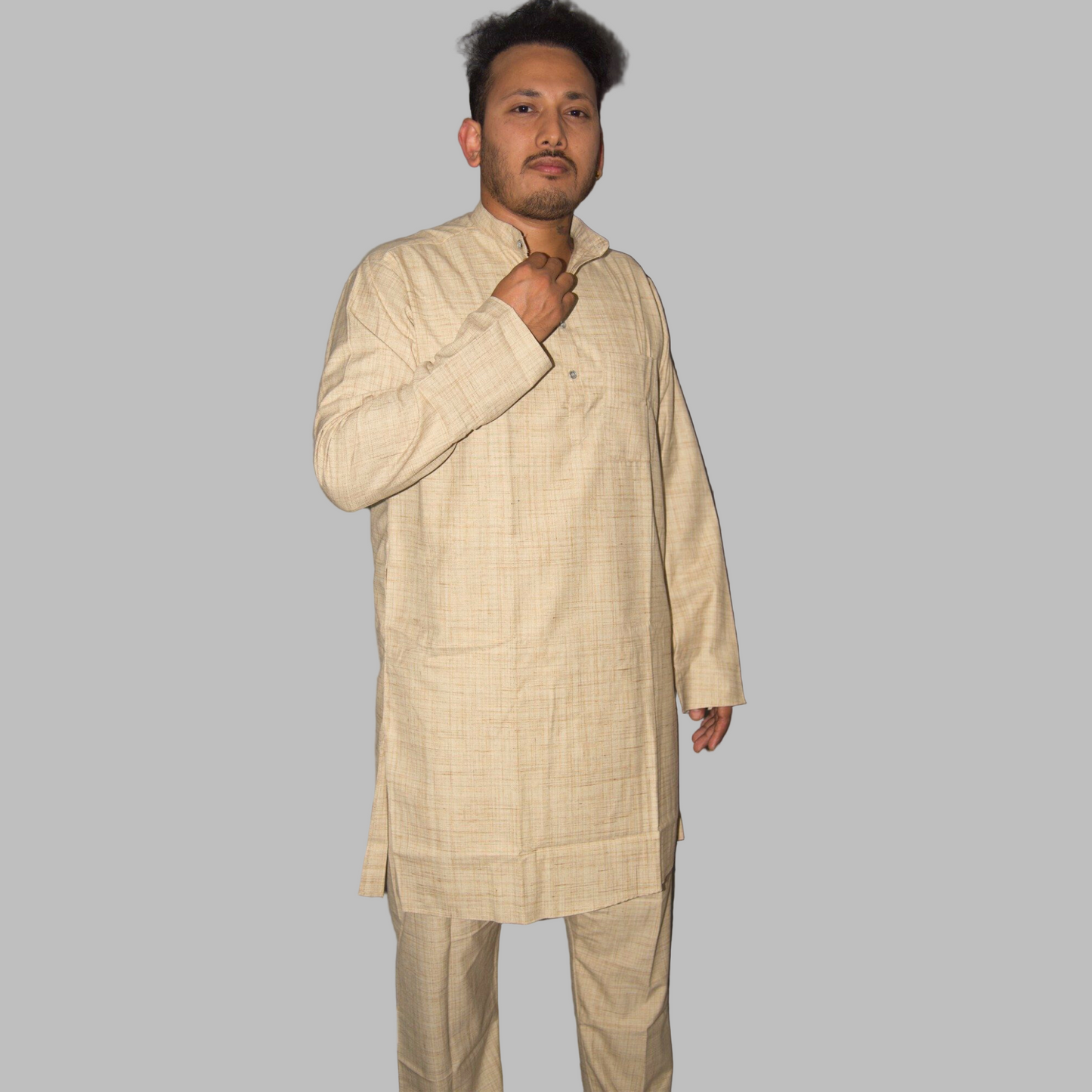 Man wearing a beige traditional outfit against a plain background