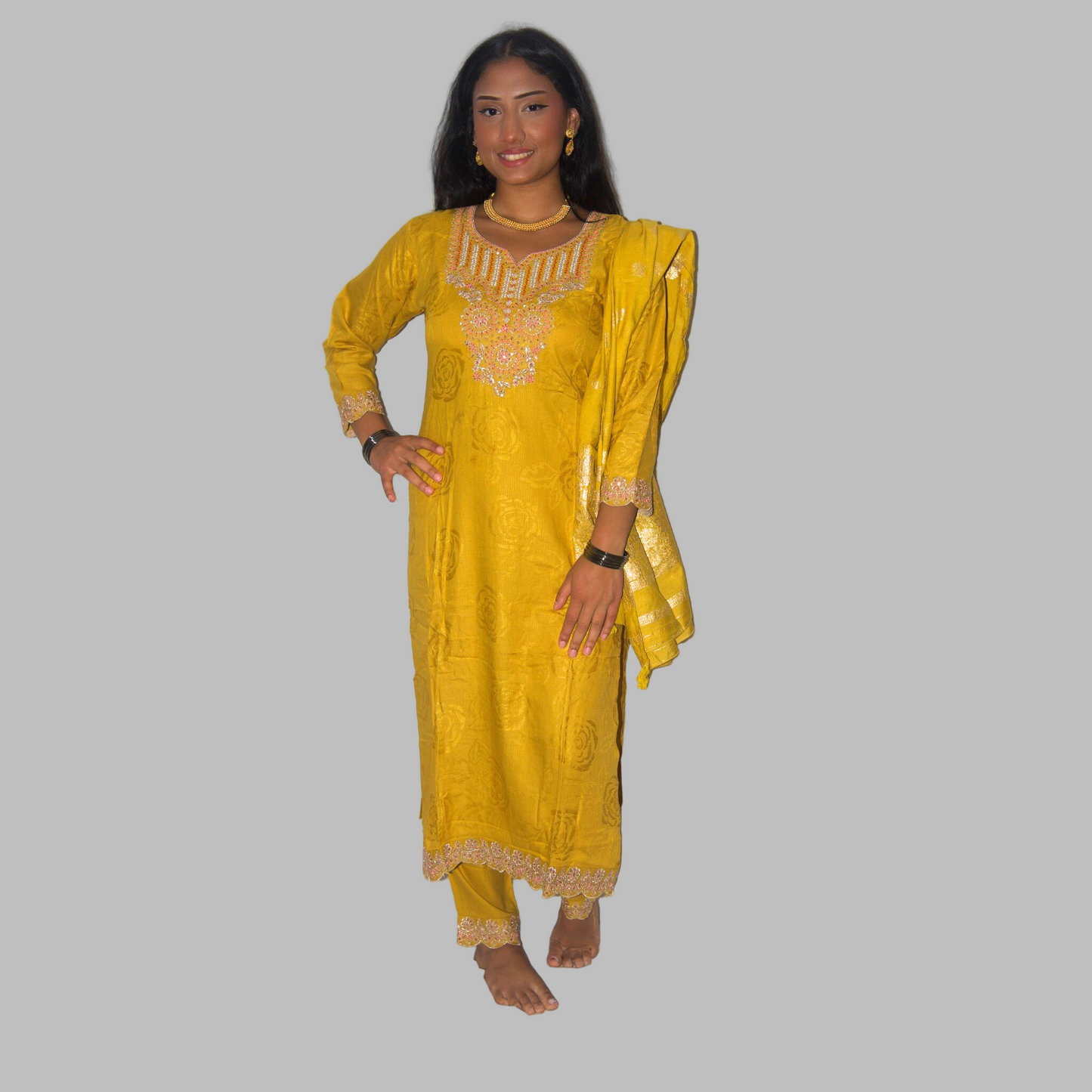 Woman wearing a yellow traditional outfit with gold embroidery on a white background