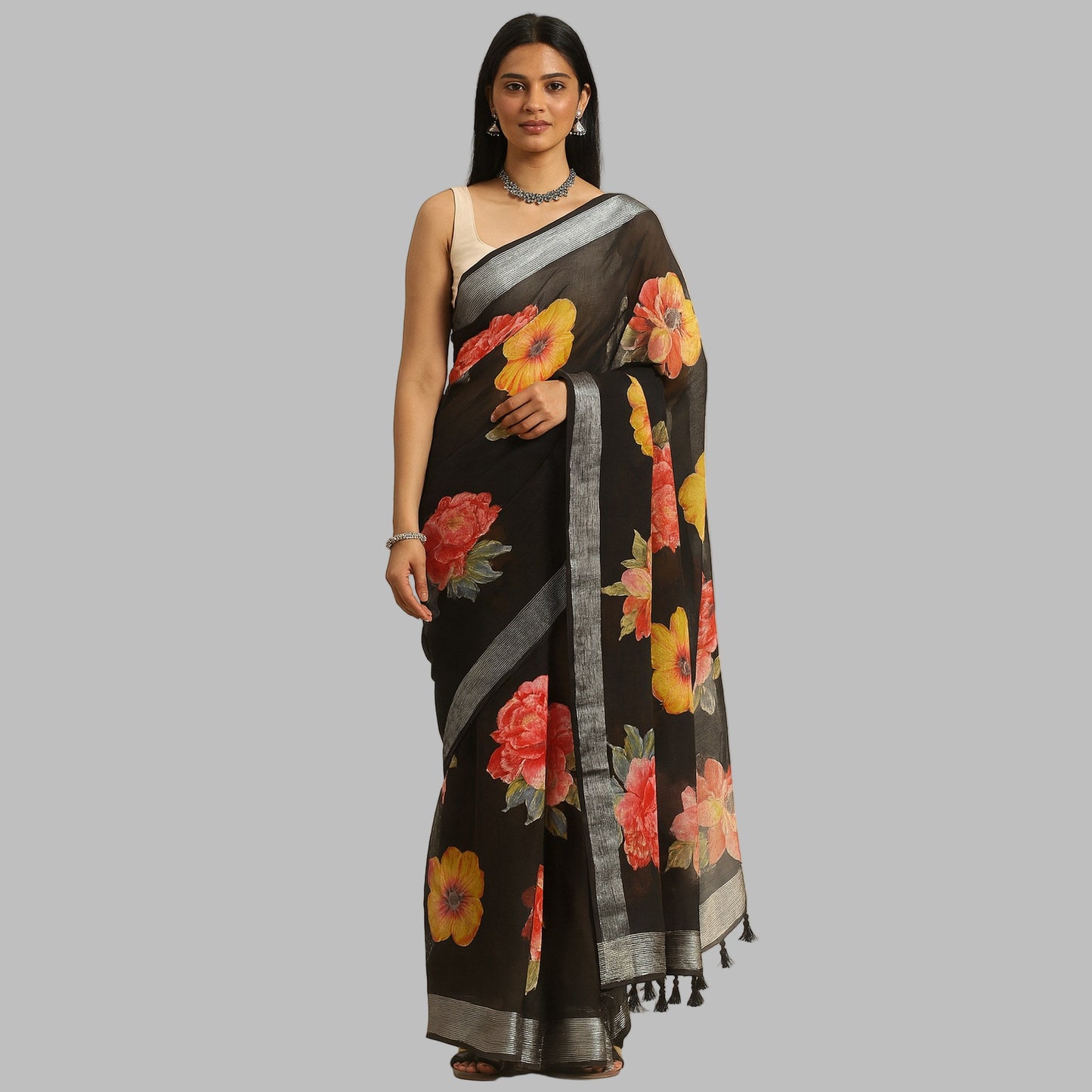 Woman wearing a black floral saree on a beige background
