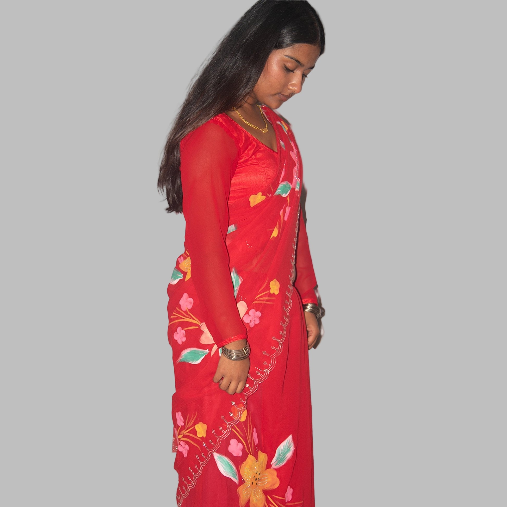 Woman wearing a red floral dress on a plain background