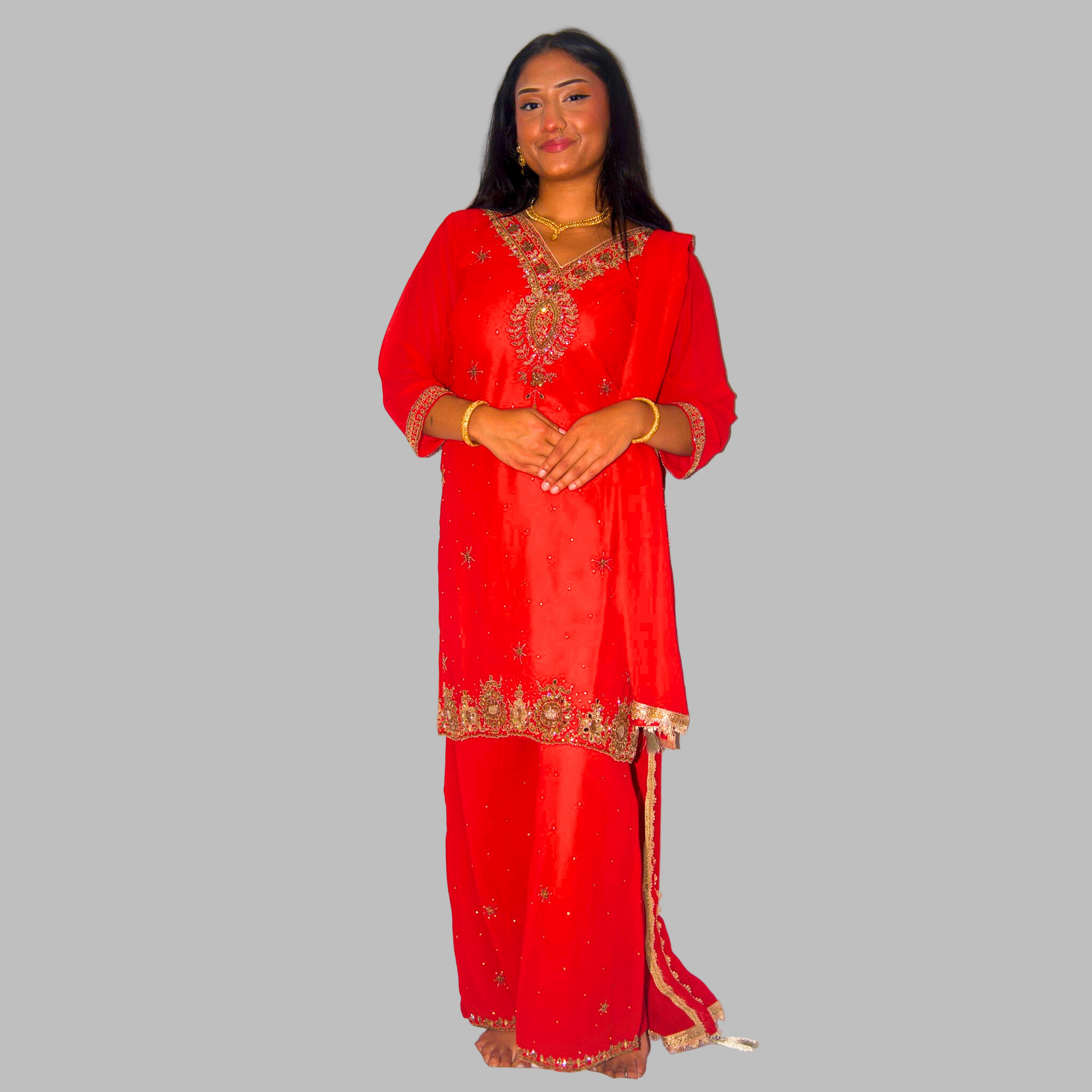 Woman wearing a red traditional outfit with gold embroidery on a white background