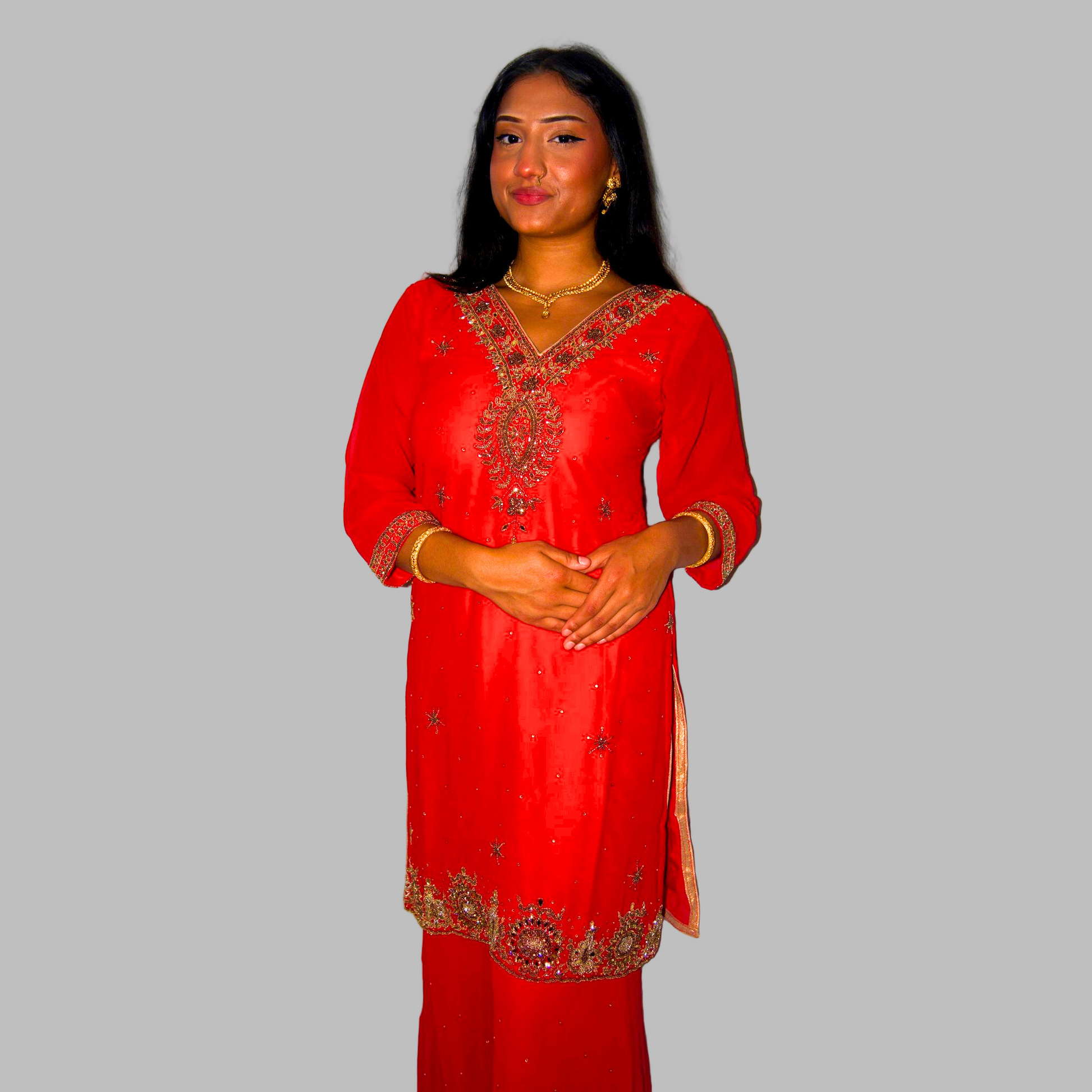 Woman wearing a red embroidered traditional outfit against a white background