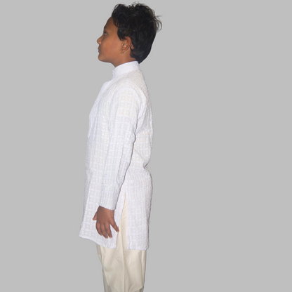 Person wearing a white shirt and beige pants against a plain background