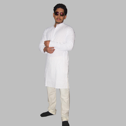 Man wearing a white kurta with beige pants against a plain background