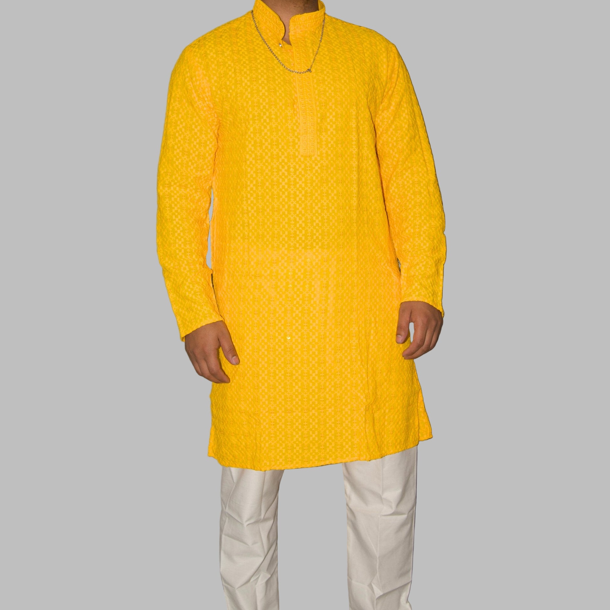 Person wearing a yellow kurta with white pants against a gray background