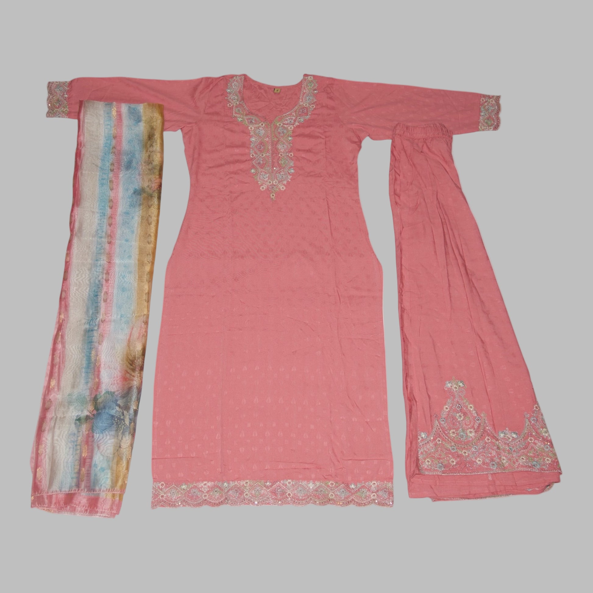 Pink traditional outfit with embroidered details on a white background