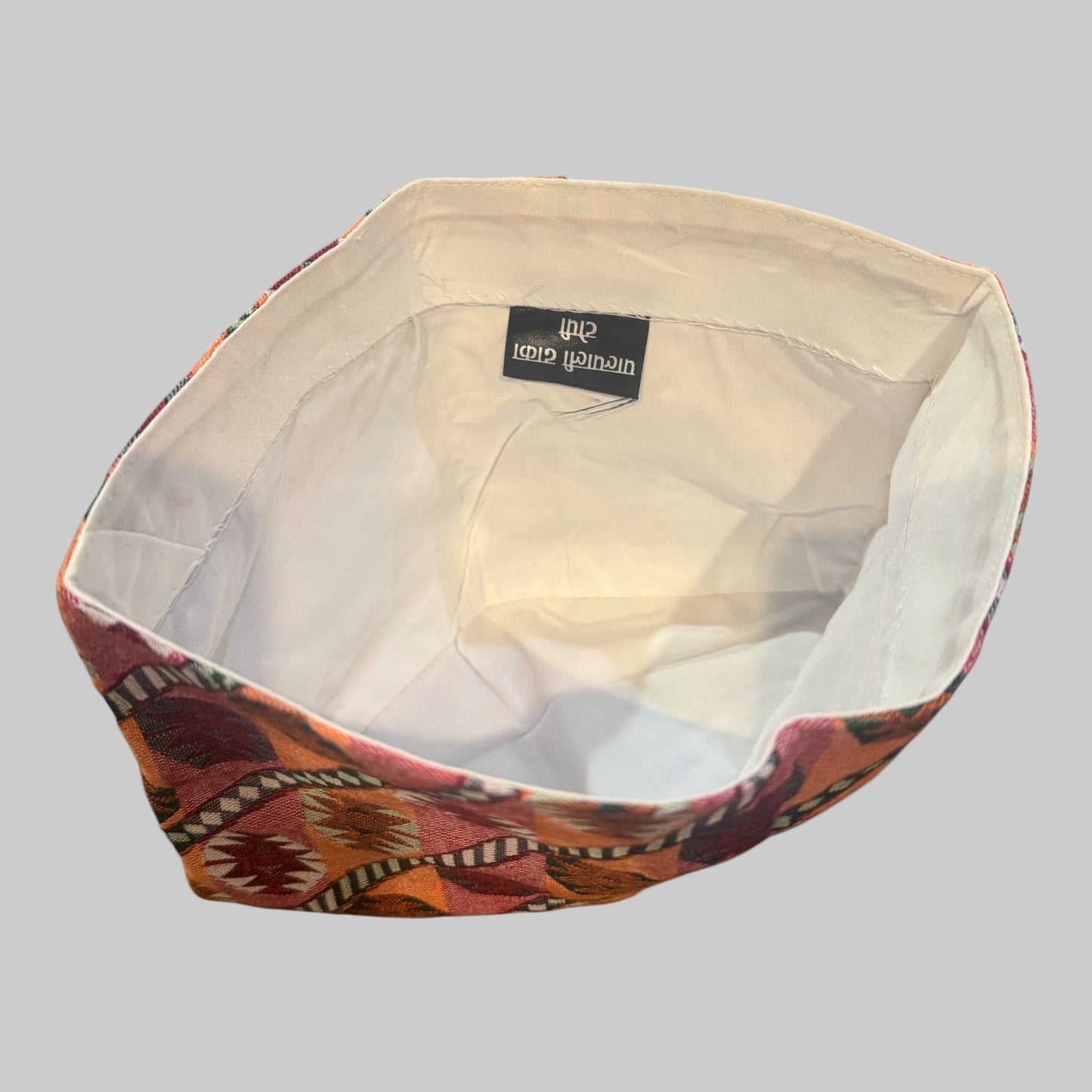 Decorative inner dhaka topi with geometric pattern on a white background