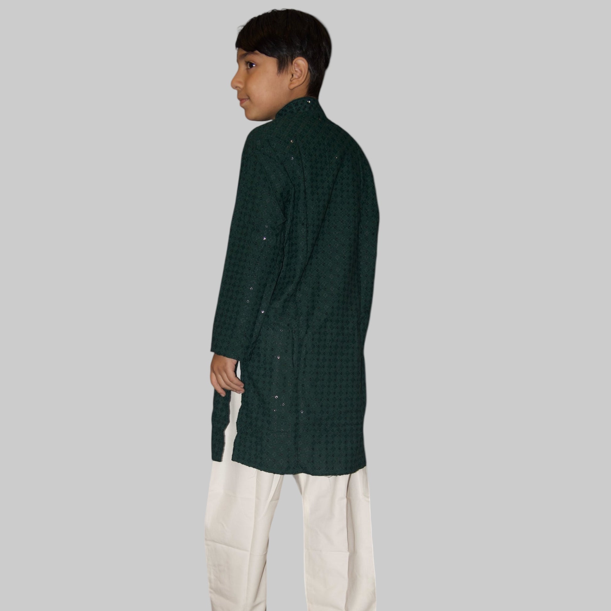 Person wearing a green checkered kurta with white pants on a white background