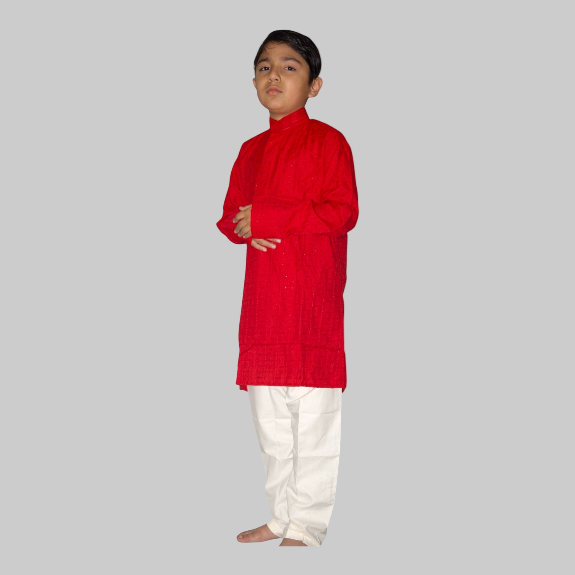 Child wearing a red kurta with white pants on a white background
