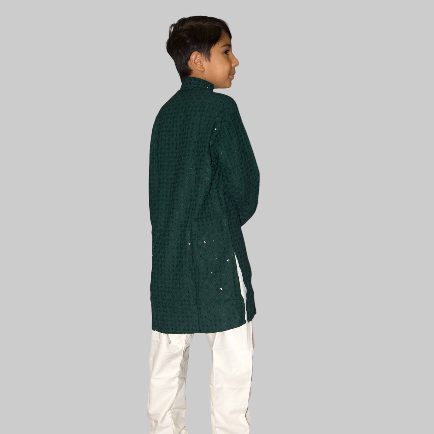 Child wearing a green checkered kurta with white pants on a white background