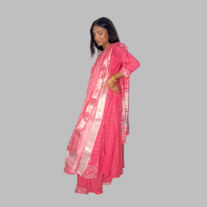 Woman wearing a pink saree with a white border on a white background