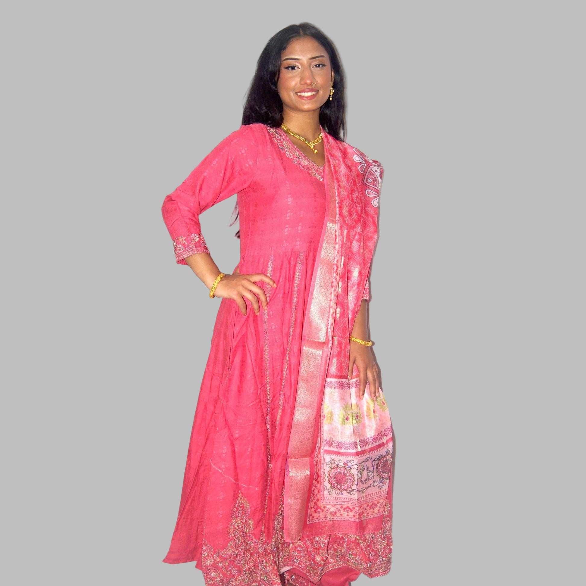 Woman wearing a pink traditional outfit with a matching dupatta on a white background