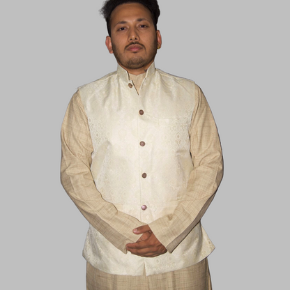Man wearing a cream-colored traditional outfit with a vest against a gray background
