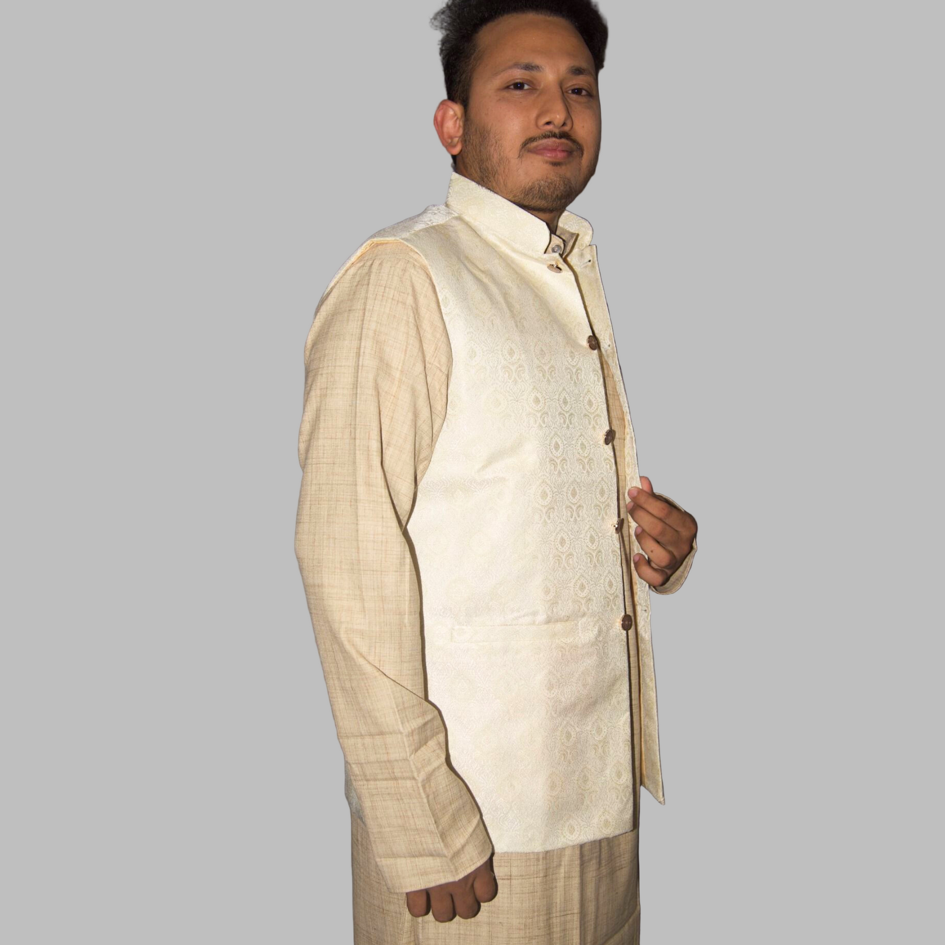 Man wearing a cream-colored traditional outfit with a vest against a plain background