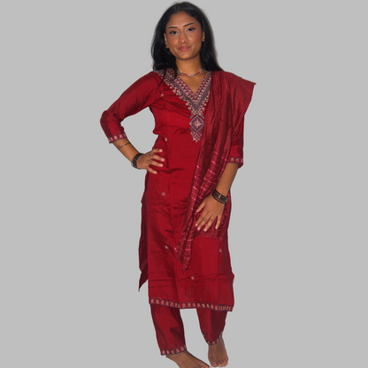 Woman wearing a traditional red outfit with intricate patterns on a white background