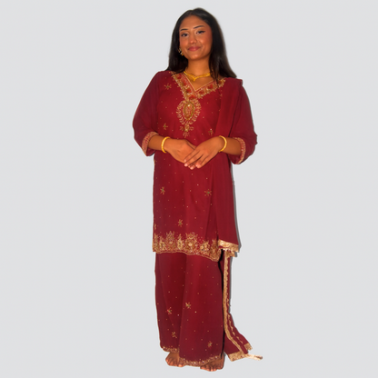 Woman wearing a red traditional outfit with gold embroidery on a white background