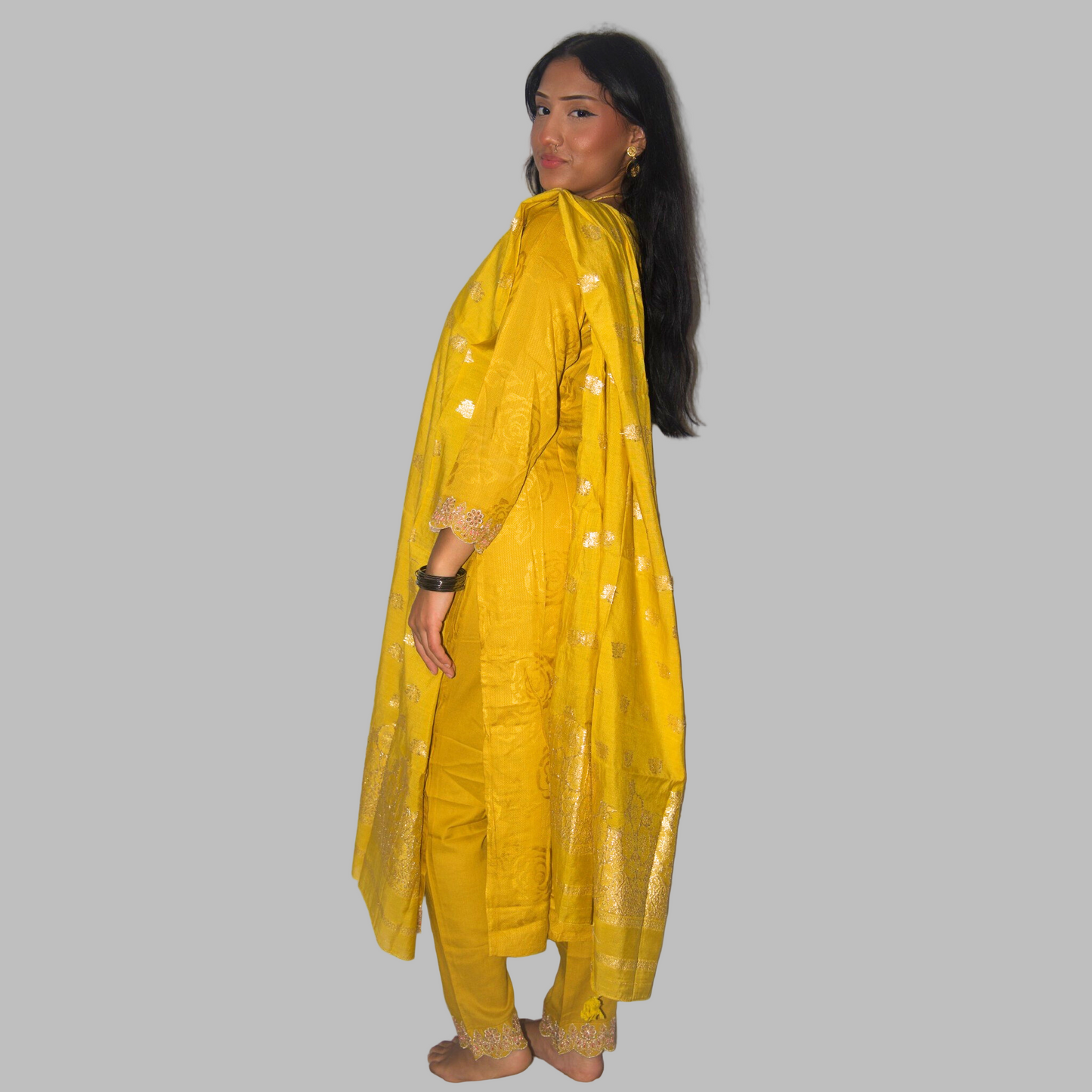 Woman wearing a yellow traditional outfit with a white background