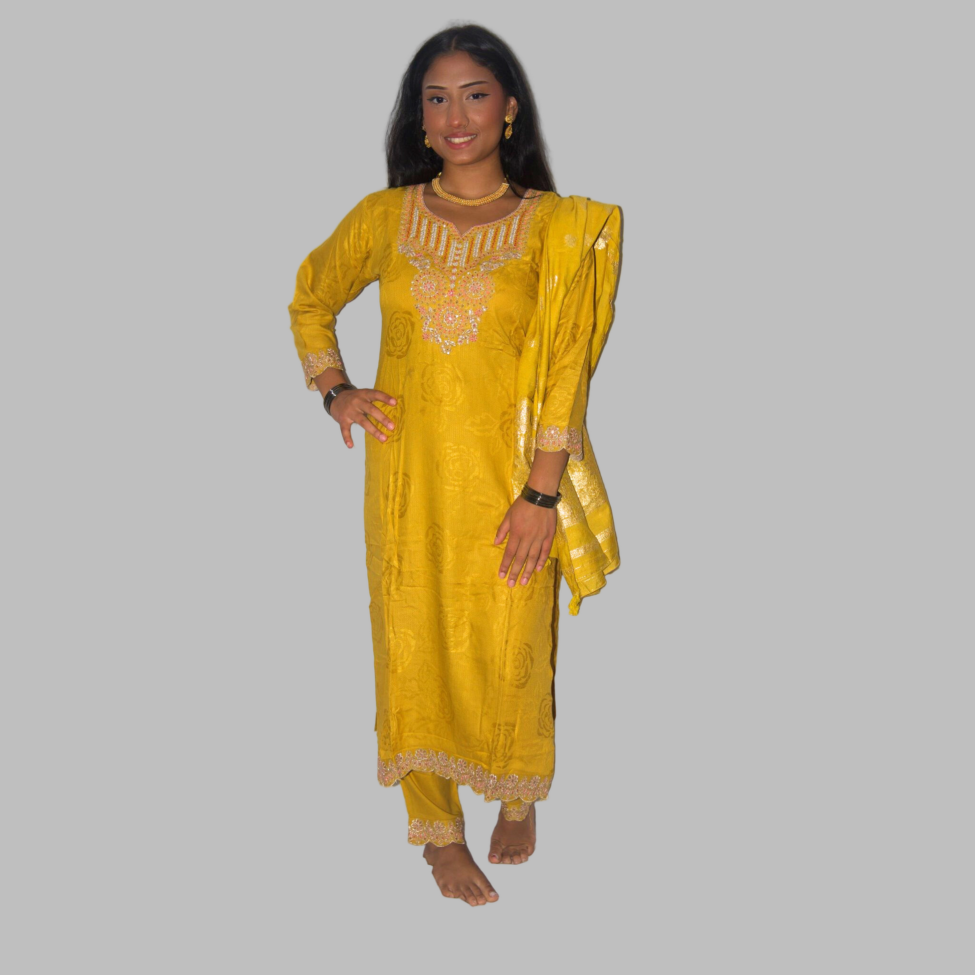 Woman wearing a yellow traditional outfit with gold embroidery on a white background
