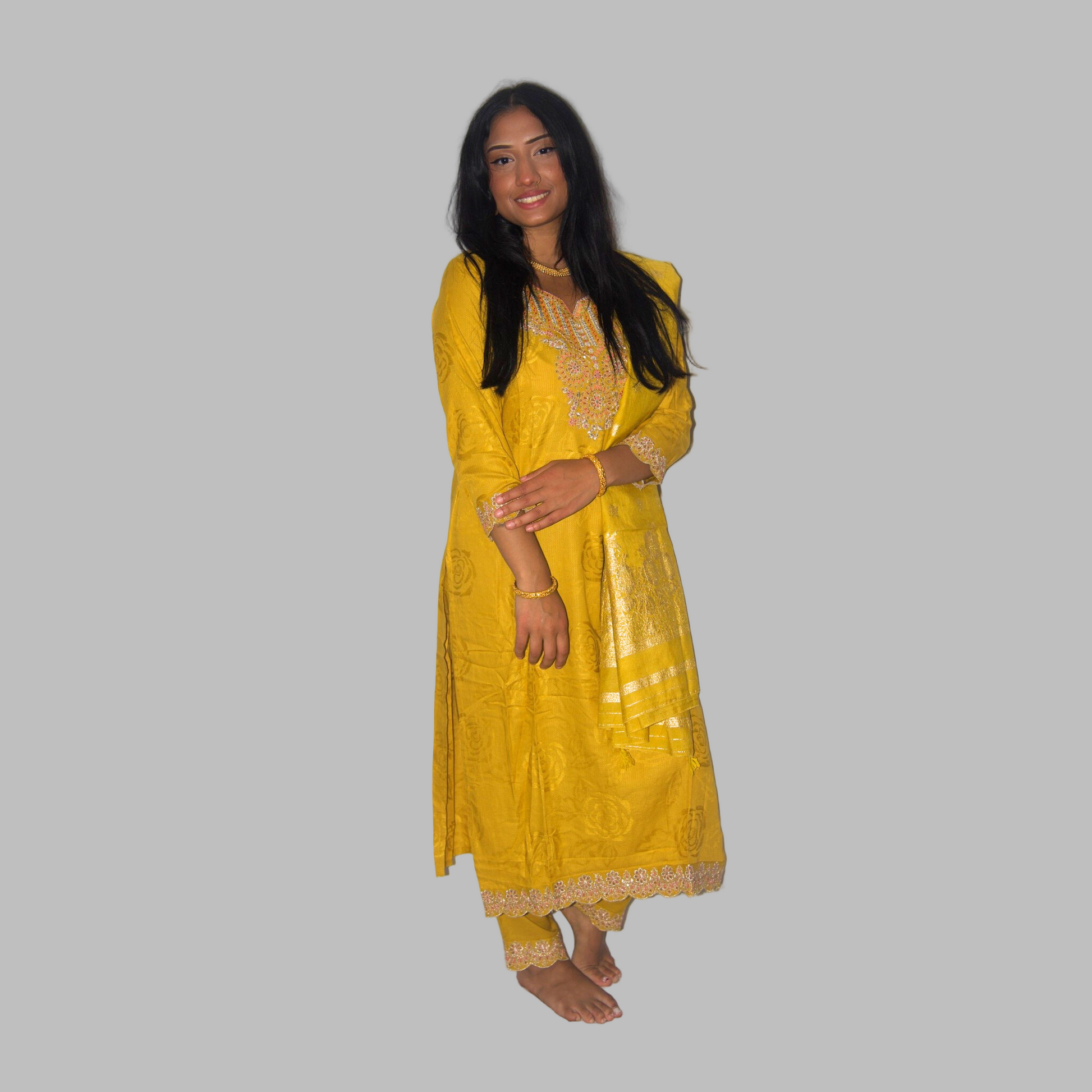 Woman wearing a yellow traditional outfit against a white background