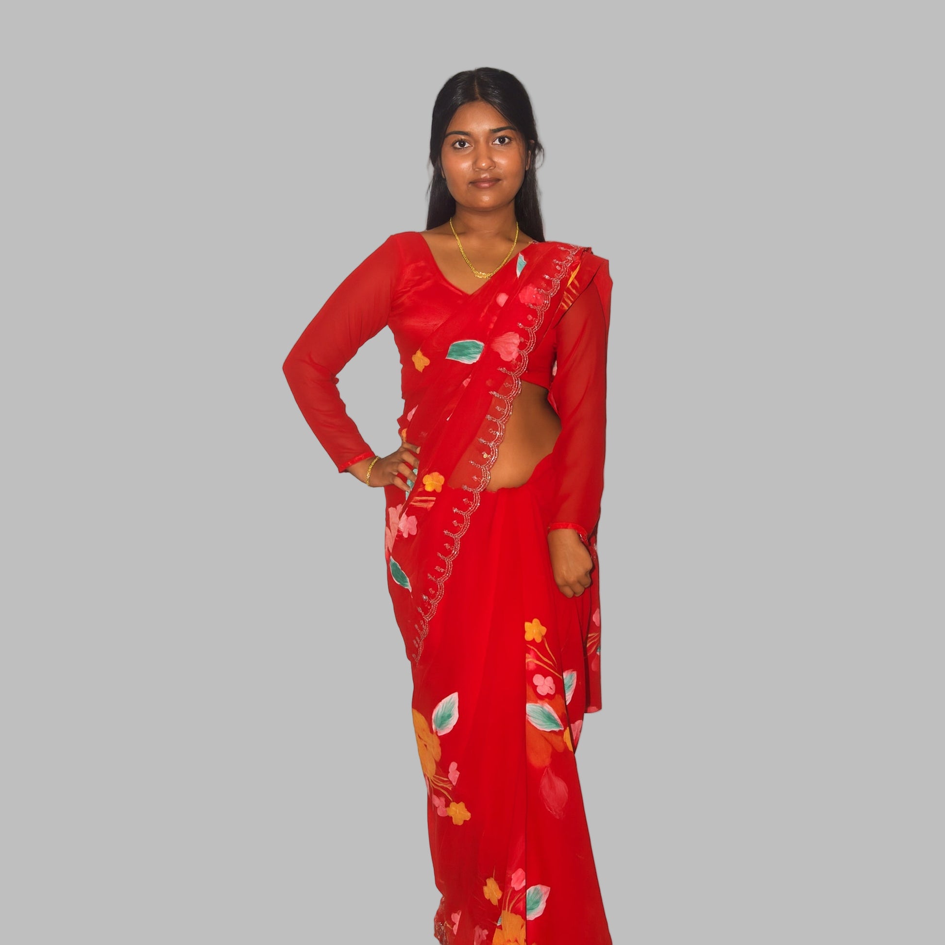 Woman wearing a red saree with floral patterns on a white background