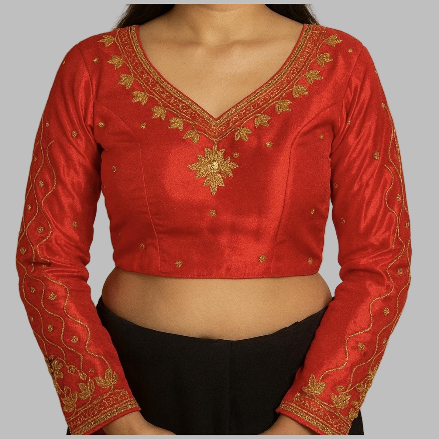 Red embroidered blouse with gold details on a beige background