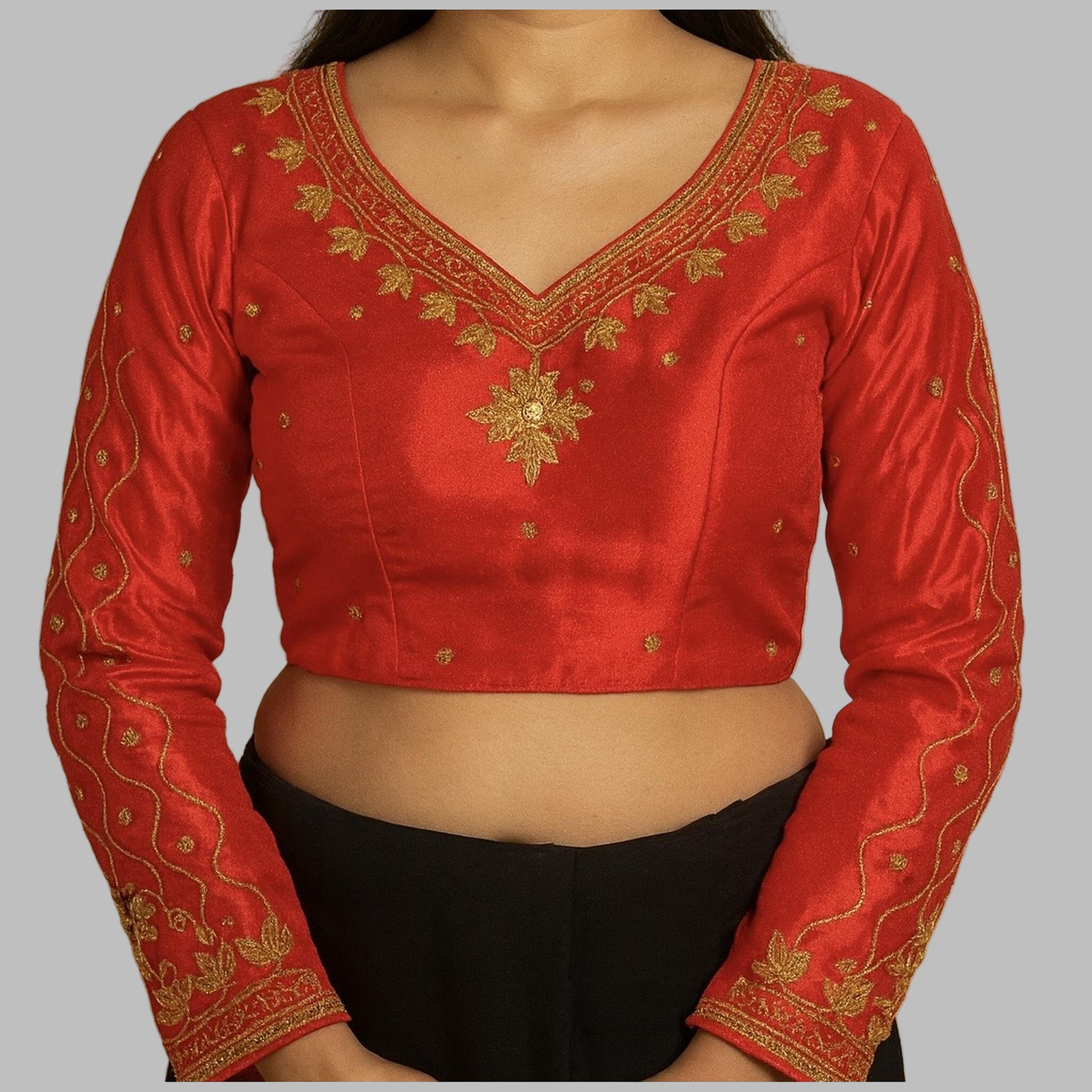 Red embroidered blouse with gold details on a beige background