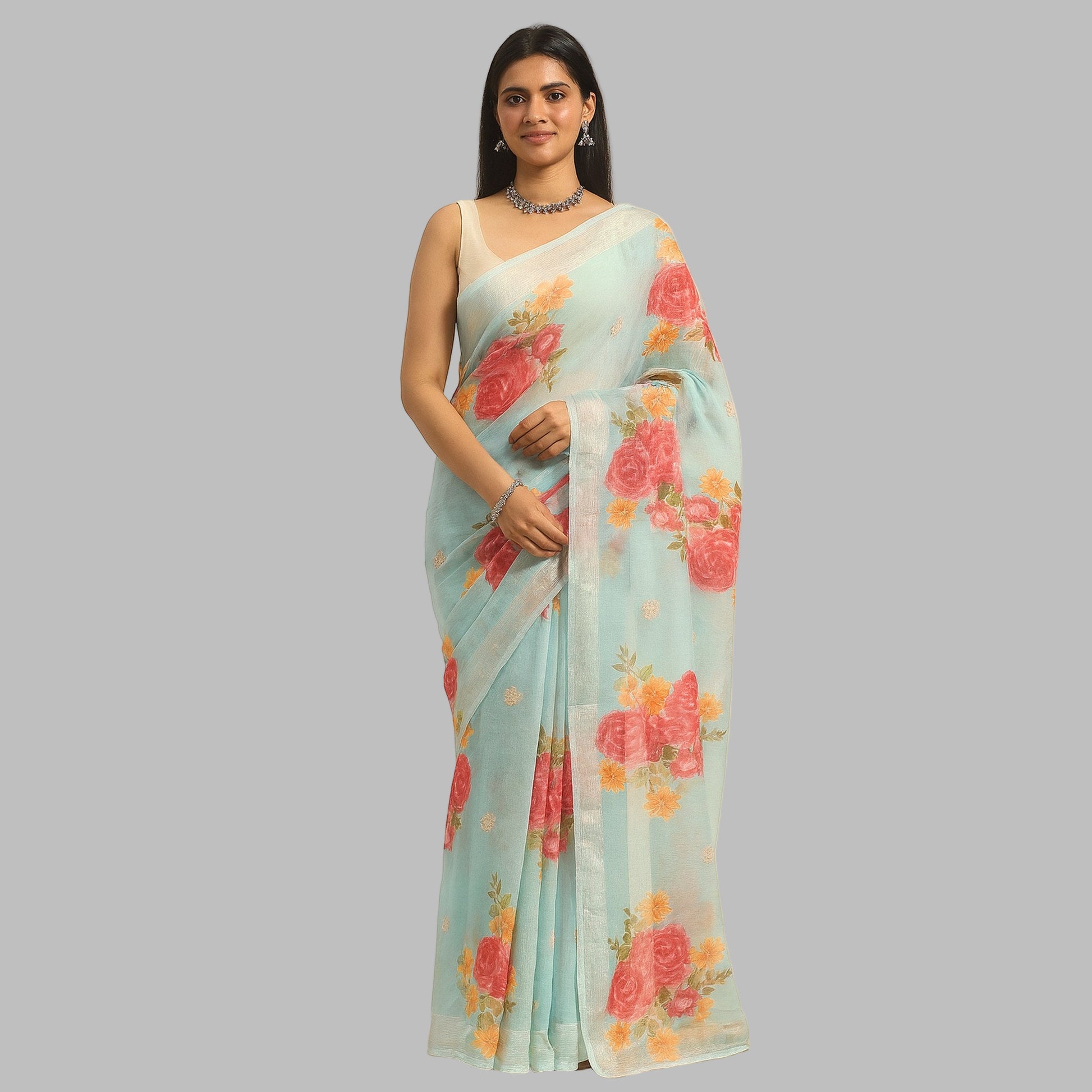 Woman wearing a light blue saree with floral patterns on a beige background