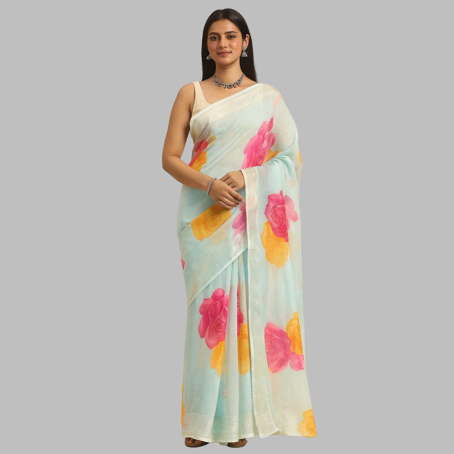 Woman wearing a light blue saree with pink and yellow floral patterns on a beige background