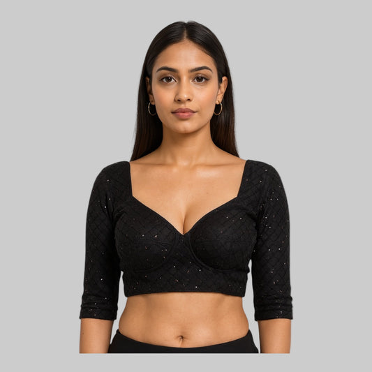 Woman wearing a black blouse with silver embellishments on a white background